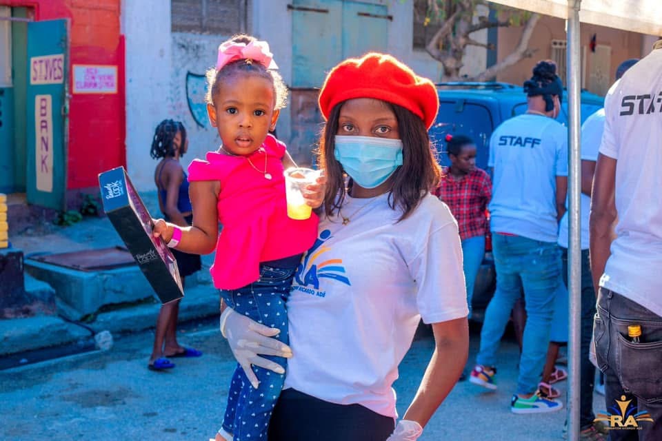 A foundation volunteer holding a child during a gift and care distribution