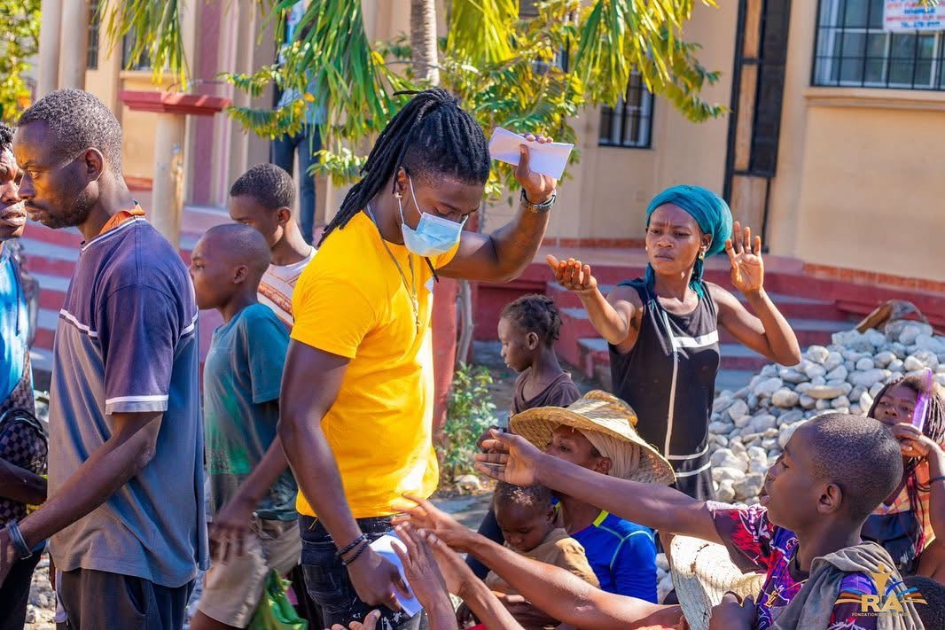 A volunteer distributing items to families during a community outreach event