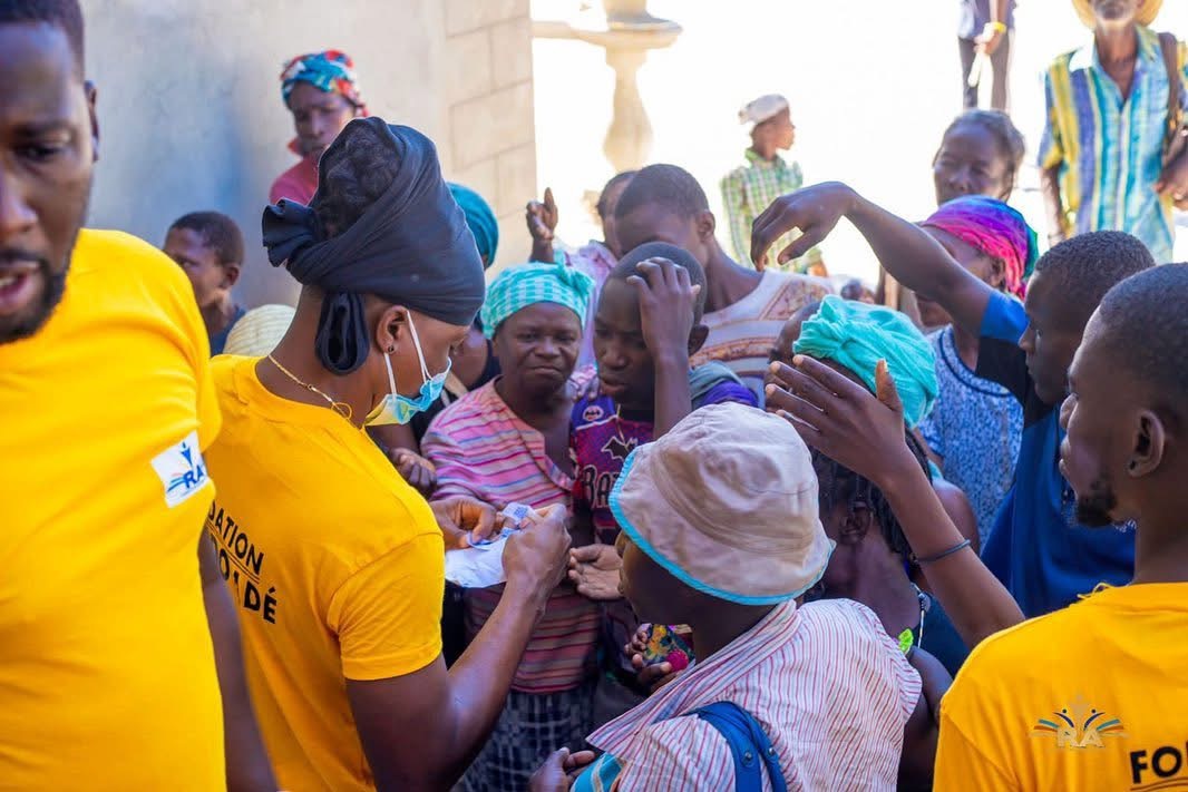Fondasyon Ricardo Ade volunteers in yellow shirts distributing aid to families in Haiti