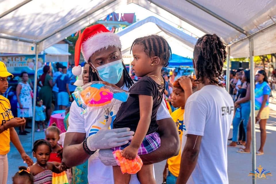A child receiving a holiday gift from a foundation volunteer in Haiti